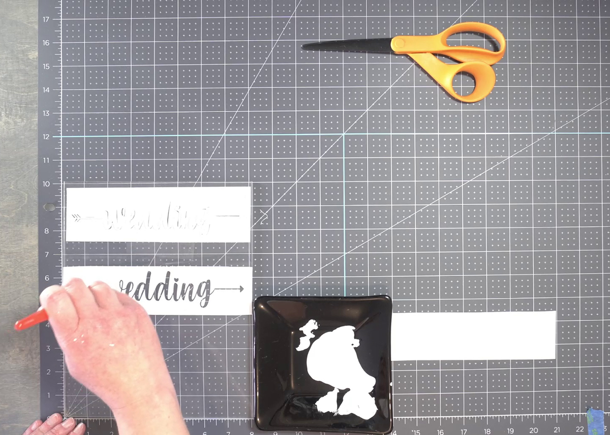 Paint the acrylic sign using a stencil paint brush