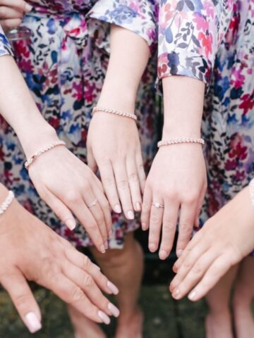 Group of women's hands displaying matching bracelets